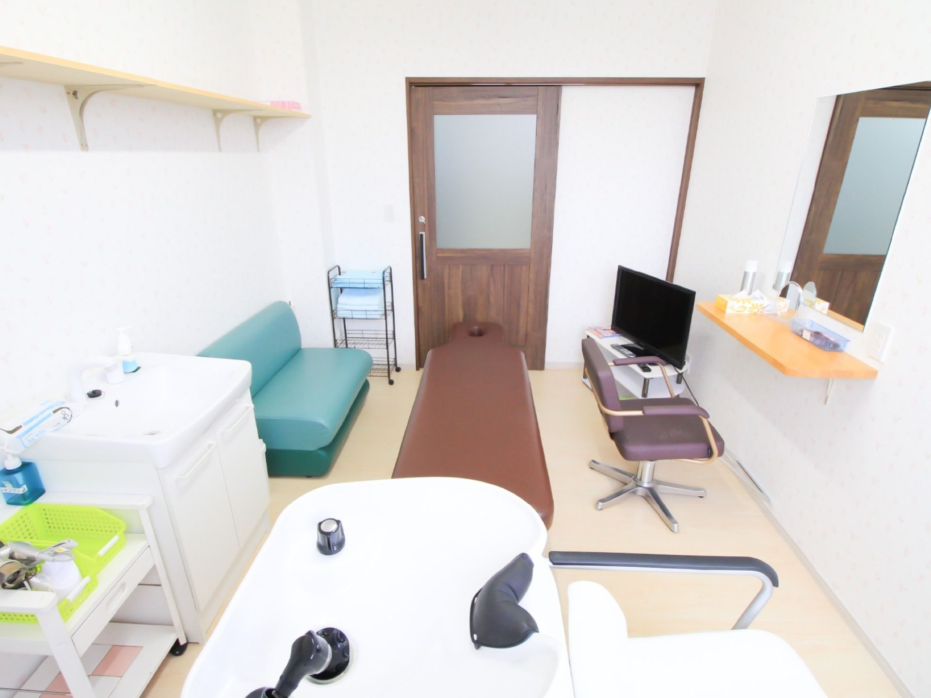 白を基調とした明るくシンプルな理美容室である。シャンプー台やカット台が完備されており、ソファが置かれている。