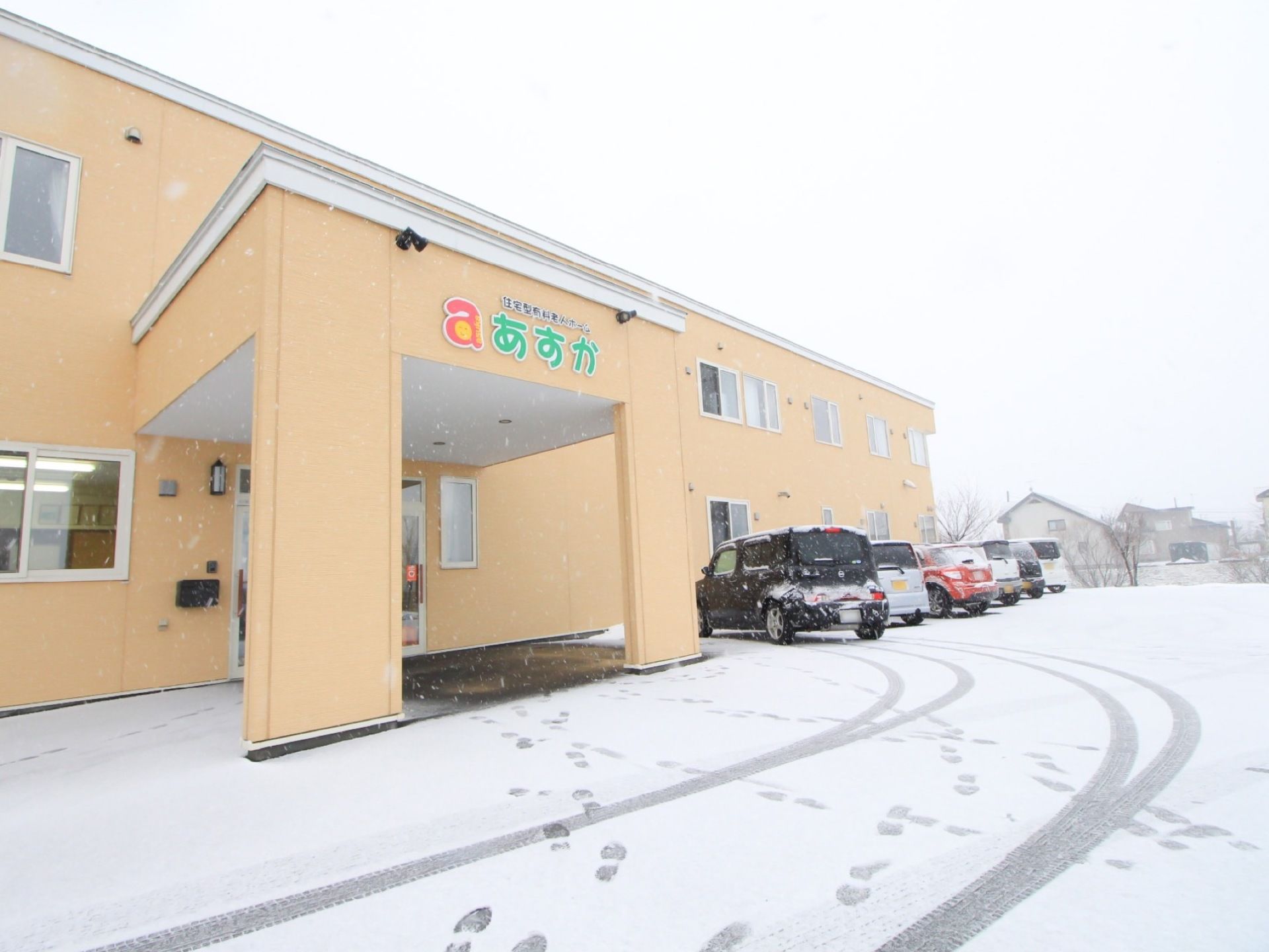 施設はクリーム色の２階建ての建物である。エントランスに車寄せが設けられており、建物前が駐車スペースになっている。