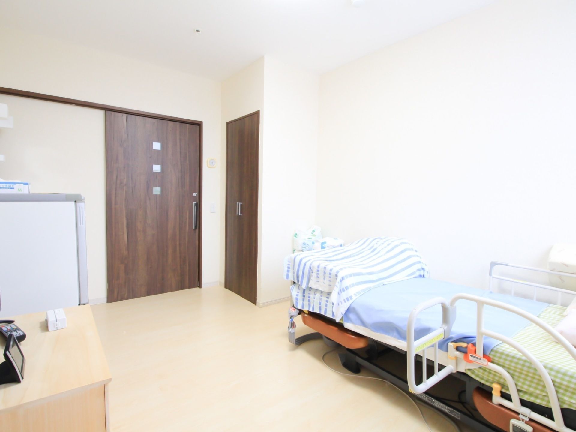 洋室タイプの居室には、介護ベッドやクローゼットが備わっている。部屋の出入り口の扉はスライドドアになっている。
