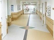 幅の広い廊下には白とベージュで模様が描かれ、両サイドの壁には写真や絵画が飾られている。
