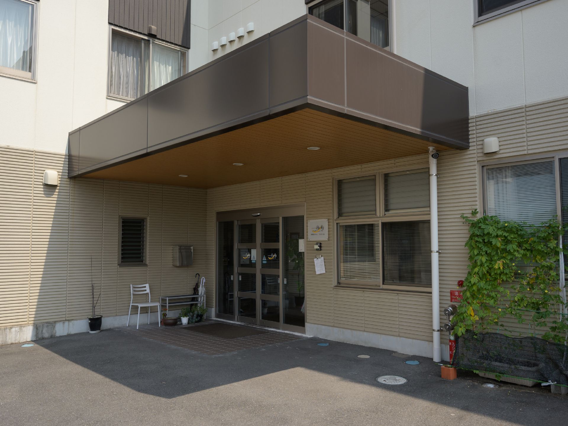 玄関扉に自動ドアを採用している大きなひさし付きのエントランス