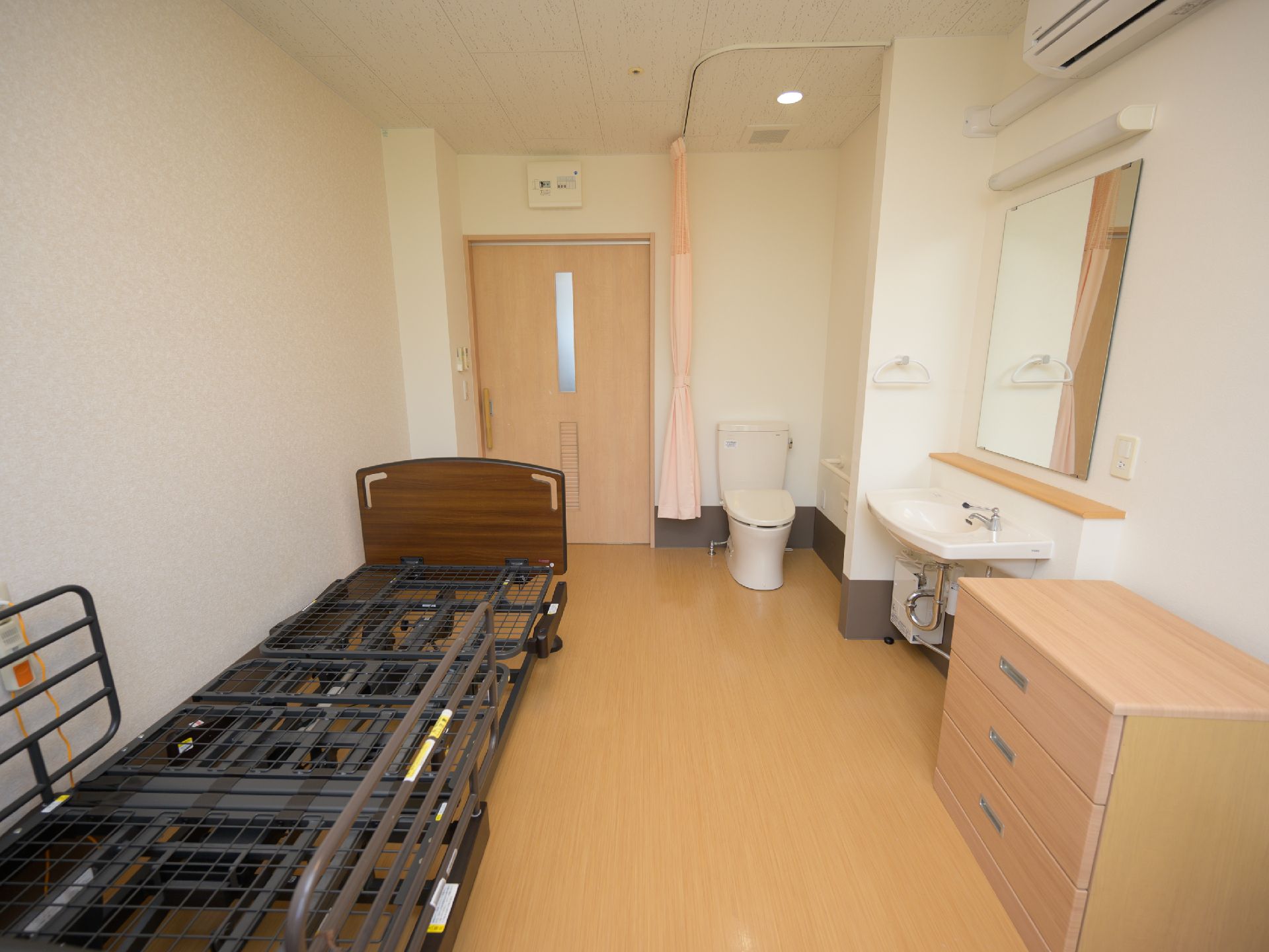 左側にベッドがある小さなワンルームの部屋。