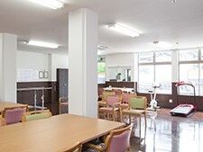 木製のダイニングテーブルが置かれているスペースの一角には複数のリハビリ機器が置かれている。
