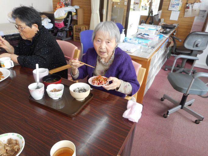 女性入居者たちが食卓を囲んでいる様子。色鮮やかな野菜を使った料理が並んでいる。