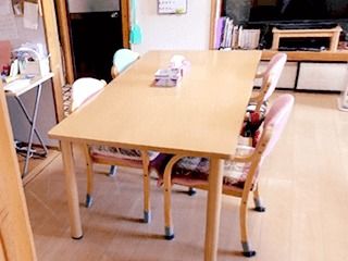 木製のダイニングテーブルが置かれた共有スペースには大きなテレビもある。