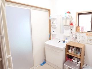 大きな引き戸を使用した浴室。脱衣所には洗面所や棚があり、張り紙もたくさん貼られている。