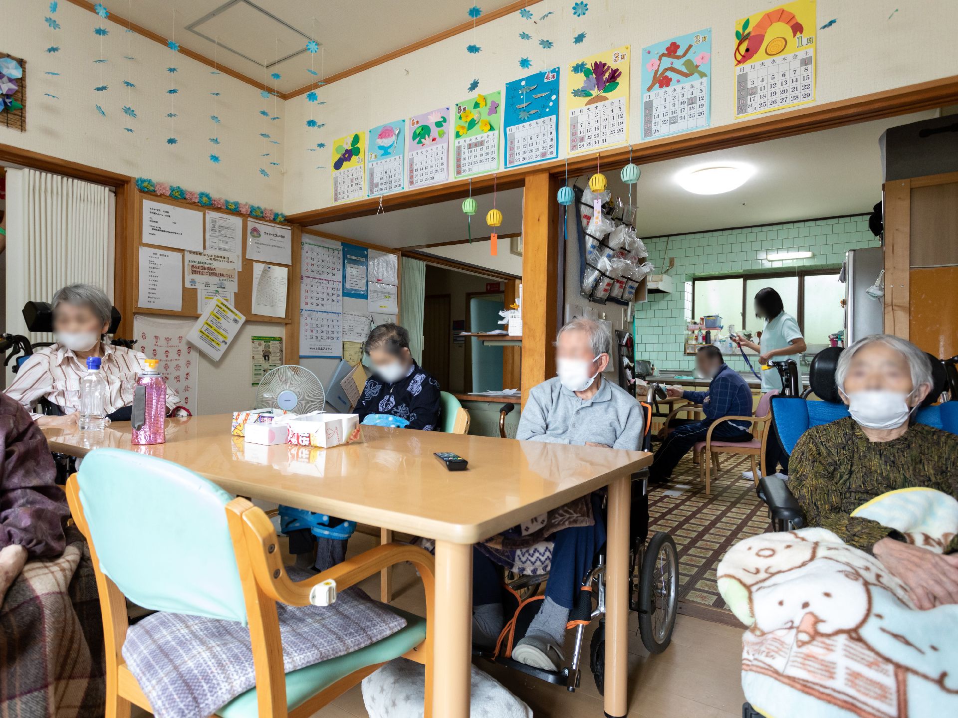 木製の机の周りに集まる入居者様