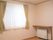 窓がある小さなワンルームタイプの部屋。施設内の居室の写真