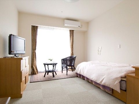居室はベッド、キャビネット、１人用のテーブルセットを入れても、通路がたっぷりと残るスペースが確保されている。