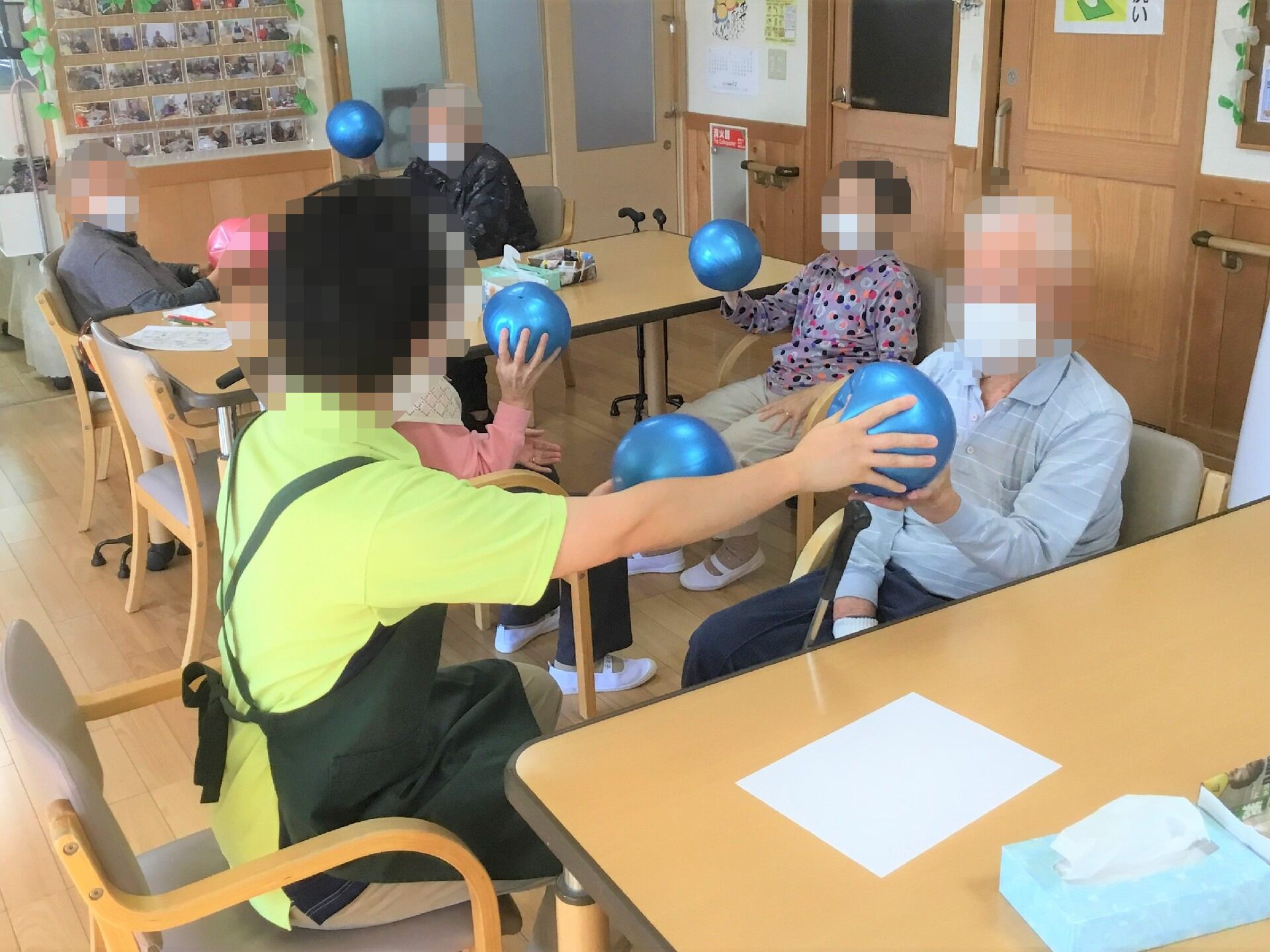 施設のスタッフが先導して体操している高齢者の様子。体を動かしている様子が写っている