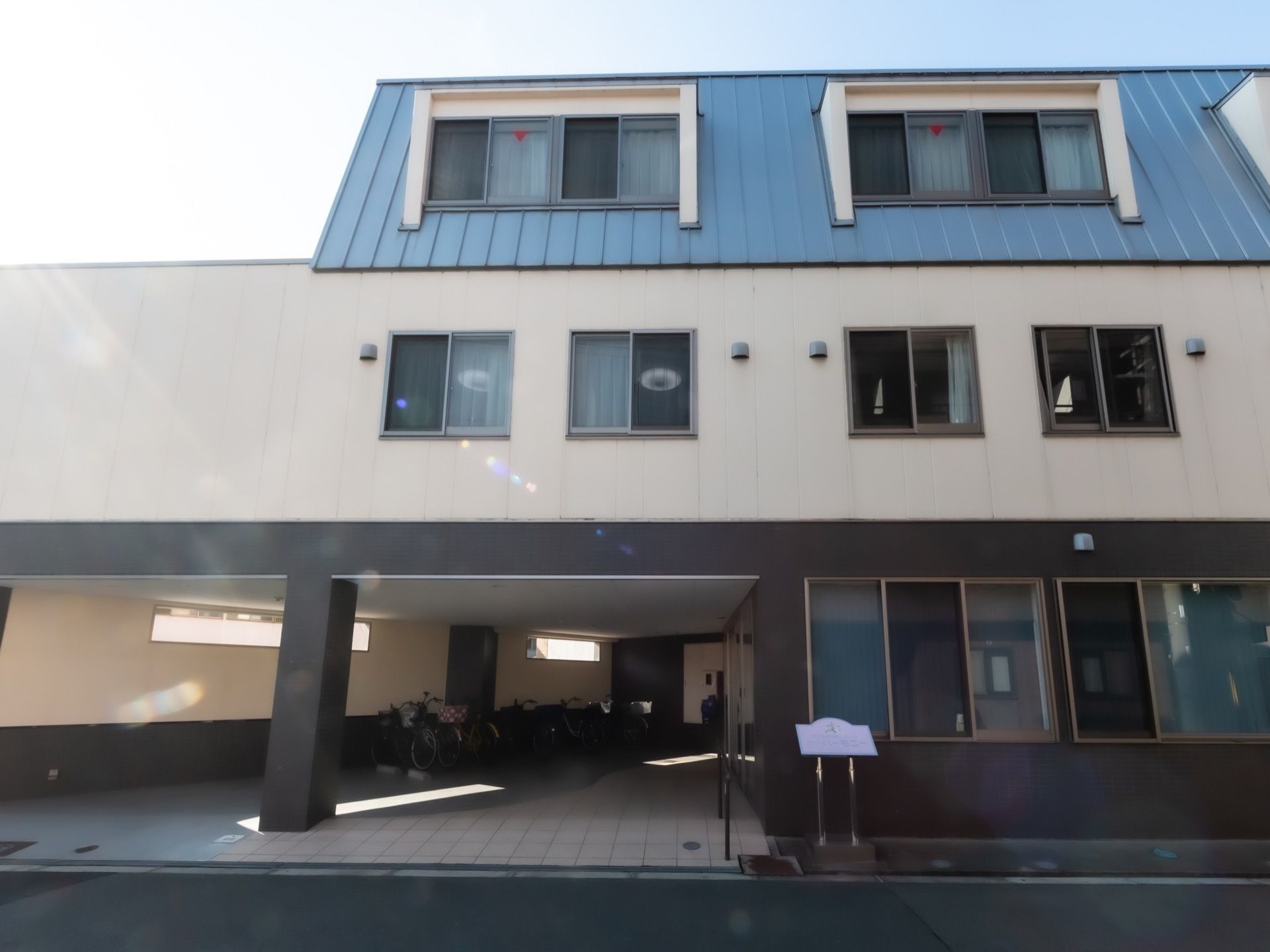 施設の１階部分は玄関への通路になっており、大きな屋根が設置されている。自転車などを置くことができるスペースとして利用することができる。