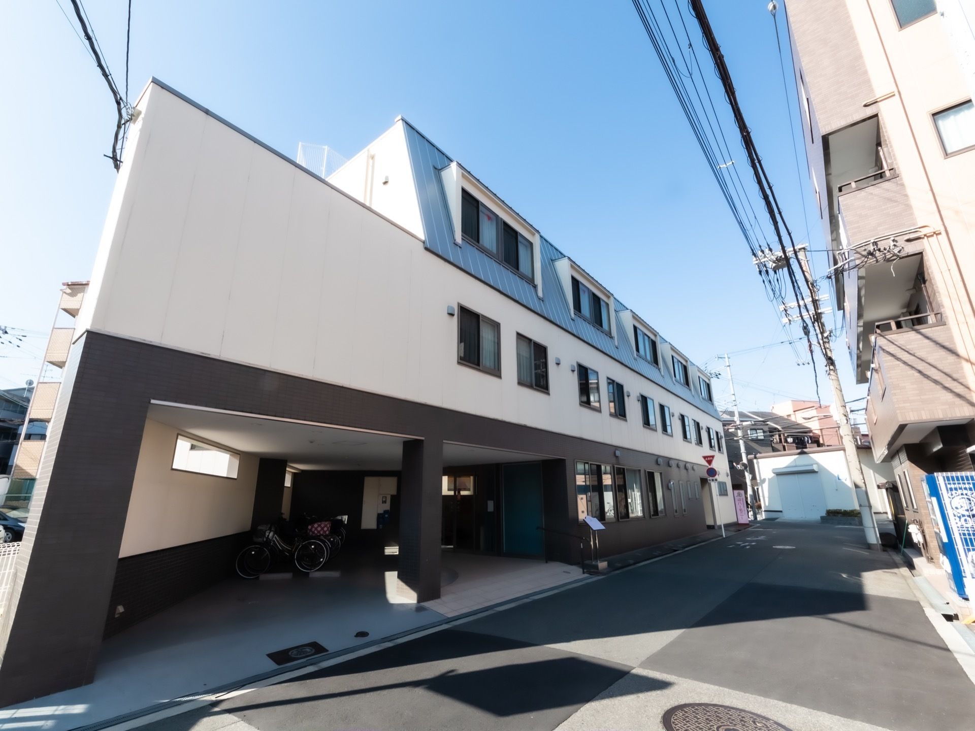 施設は住宅街に立地しており３階建ての建物になっている。屋根のある駐車スペースがあり、車での来訪も便利である。