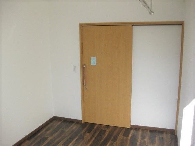 居室ドアが引き戸で力を入れなくても開けることができる。白と木目調のコントラストが親近感を持てる。