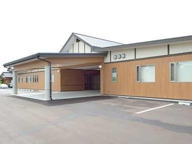 和風づくりの建物のエントランス部分周辺には駐車場や大きな車寄せがある。
