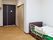 寝具付きのベッドが設置されているフローリングの部屋には他に家具はなく、ドアのそばにはトイレのドアが付いている。
