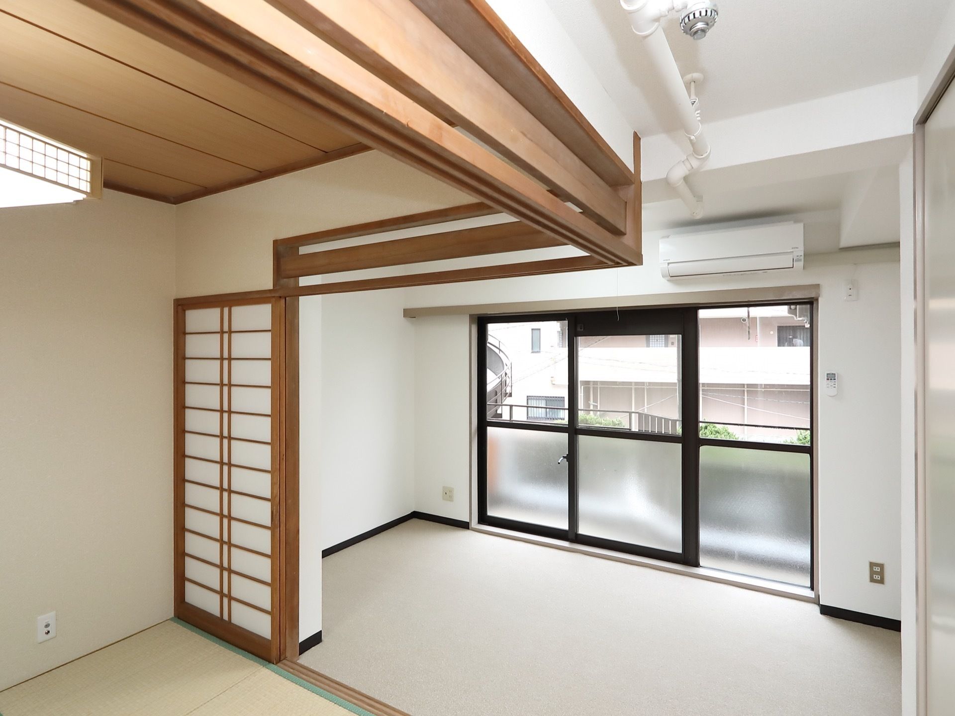 白い壁が清潔感をかもし出している明るい居室である。和室と洋室が１部屋ずつあり、障子で仕切られている。