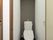 白とグレーで統一されたシンプルな雰囲気のあるトイレである。温水洗浄便座と非常呼び出しブザーが完備されている。