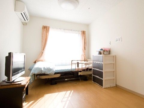 大きな窓際に介護用ベッドがある。陽が良く入る。テーブルやチェストを置くスペースがあり、お好きなインテリアを配置できる。