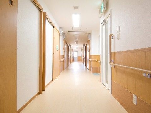 通路は一直線に伸びている。白と木目調のツートンの壁が爽やかである。手すりを設置してあるので安心して歩ける。