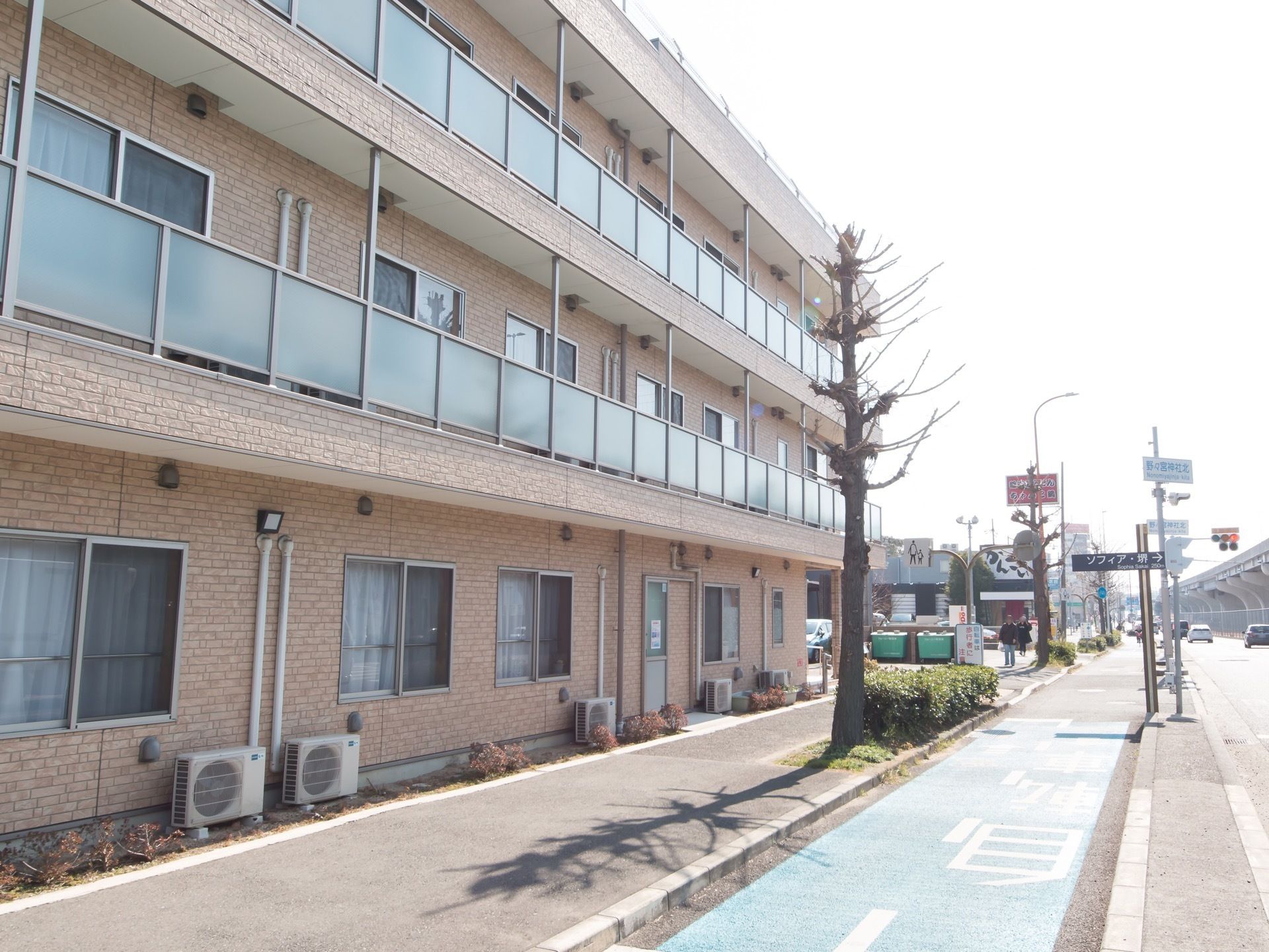 レンガが全面に貼られた３階建ての建物である。大通りに面して居室の窓が並んでいる。施設前は歩道になっている。