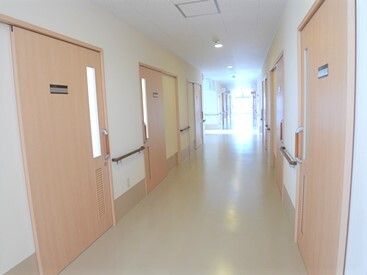 日当たりのいいまっすぐな廊下は通行の邪魔になるものが置かれておらず、両サイドにスライド式のドアが付いている。
