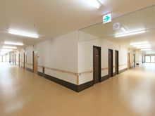 車いすでもすれ違える幅を確保してある施設内の廊下。歩行補助用の手すりが取り付けられている