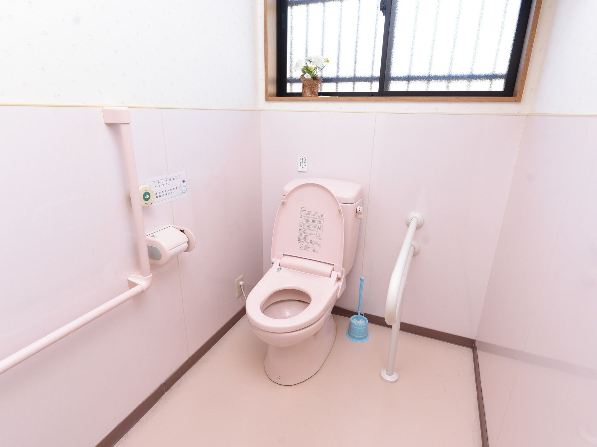 トイレには温水洗浄便座が取りつけられている。壁の上部に窓があり、外には侵入防止の鉄柵が嵌められている。