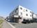 ３階建ての建物で、外壁は１階がブラウン、上が白と２色に分かれている。壁にオレンジと緑を組み合わせたロゴマークと施設名が表示されている。