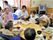 食卓を囲んで食事を楽しむ入居者。スタッフが介助をしている人もいる。