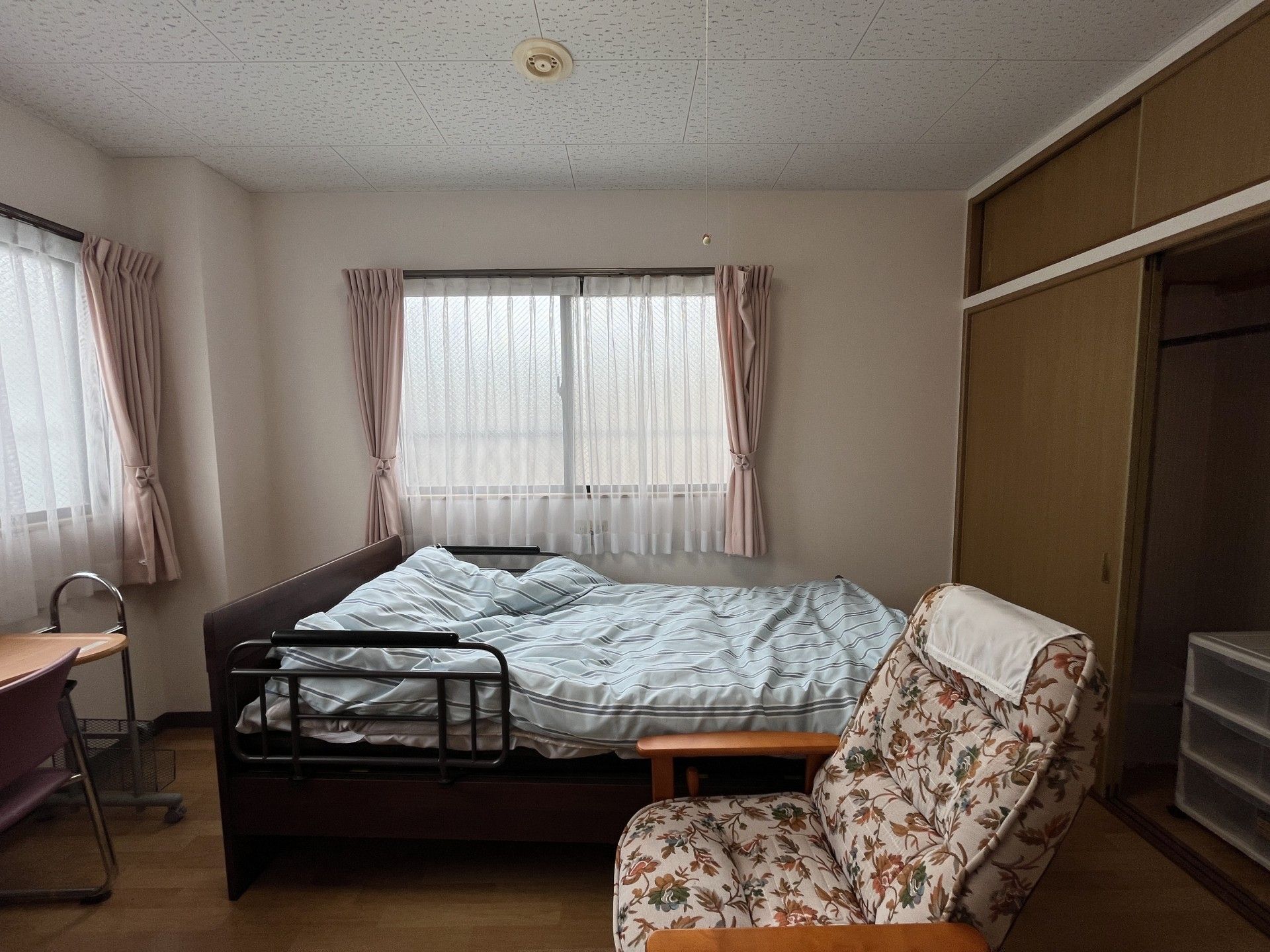 窓際のベッドと椅子の部屋