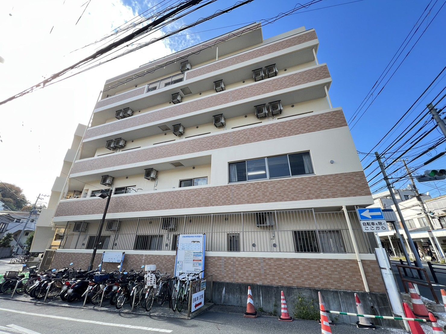 車いすに乗った女性を押す家族の男性とそこに寄り添う介護スタッフの様子