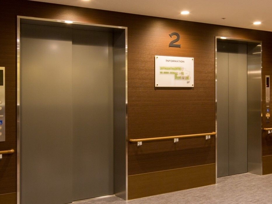 壁には手すりが付き、２基のエレベーターの中央部分の壁には「２」と書かれている。