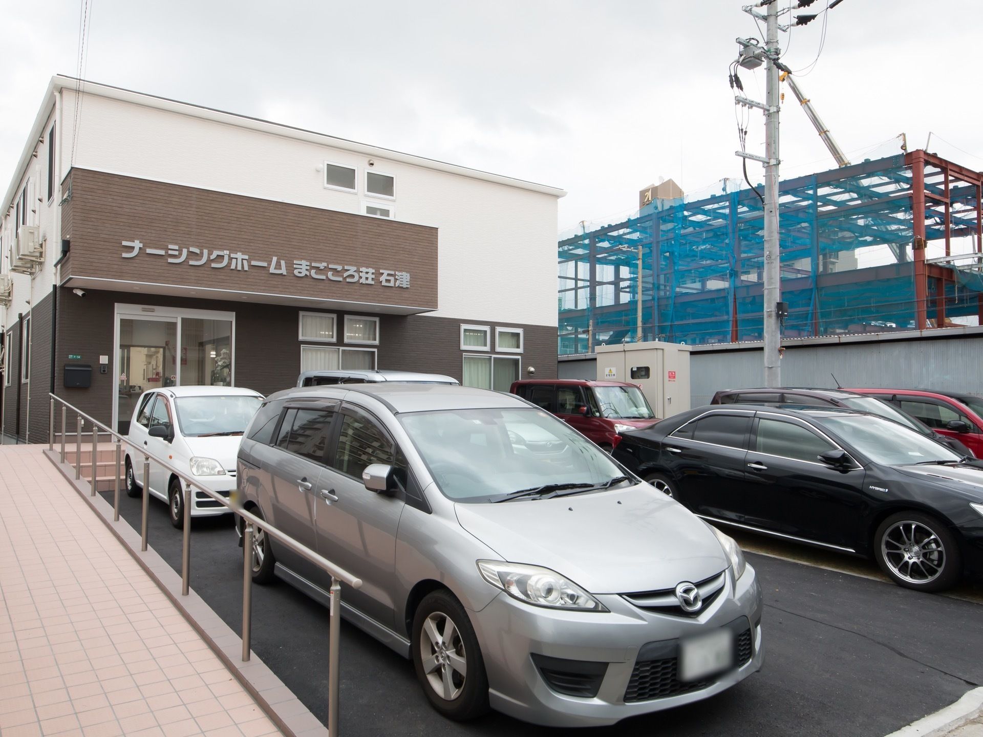 施設の前に広い駐車場を用意している。玄関前まではスロープがあり、ステンレス製の手すりが取りつけられている。