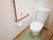 白い洋式トイレを採用している。壁にはL字型の茶色い手すりが取りつけられており、その上に非常ボタンが設置されている。