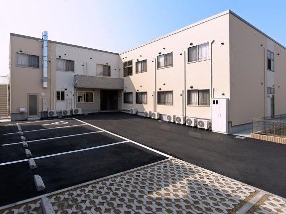 広い敷地内にはエル字型で2階建ての建物があり、ちょうど中央に玄関がある。