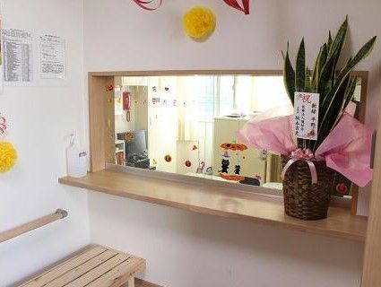 スタッフステーションの前にはベンチが置かれ、ハロウィンの飾りやお祝いの木が置かれている。