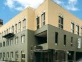 3階建ての建物はグレーとベージュの落ち着いた色合い。