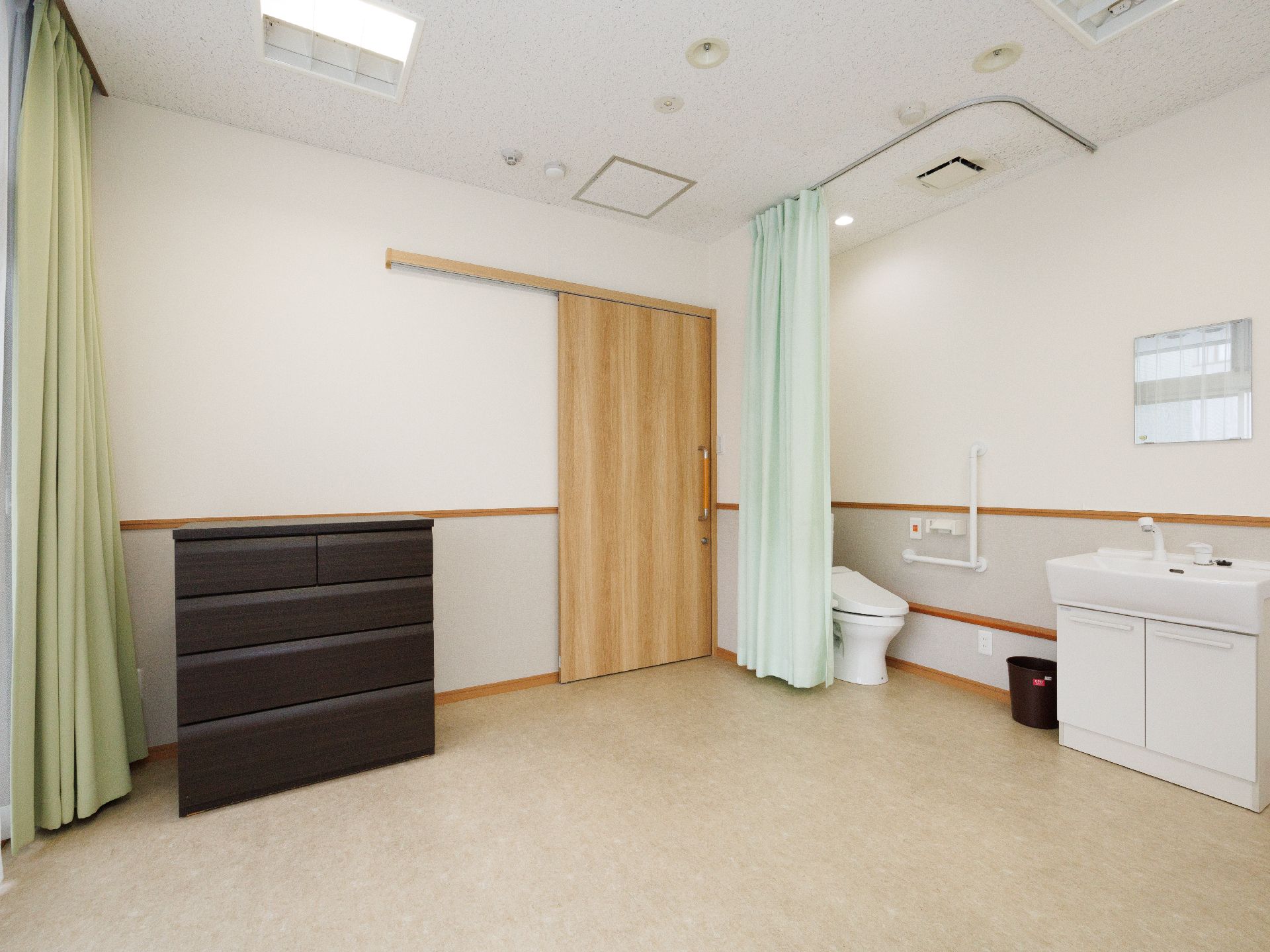 日差しが差し込み、介護ベッドや家具に日差しが当たっている居室