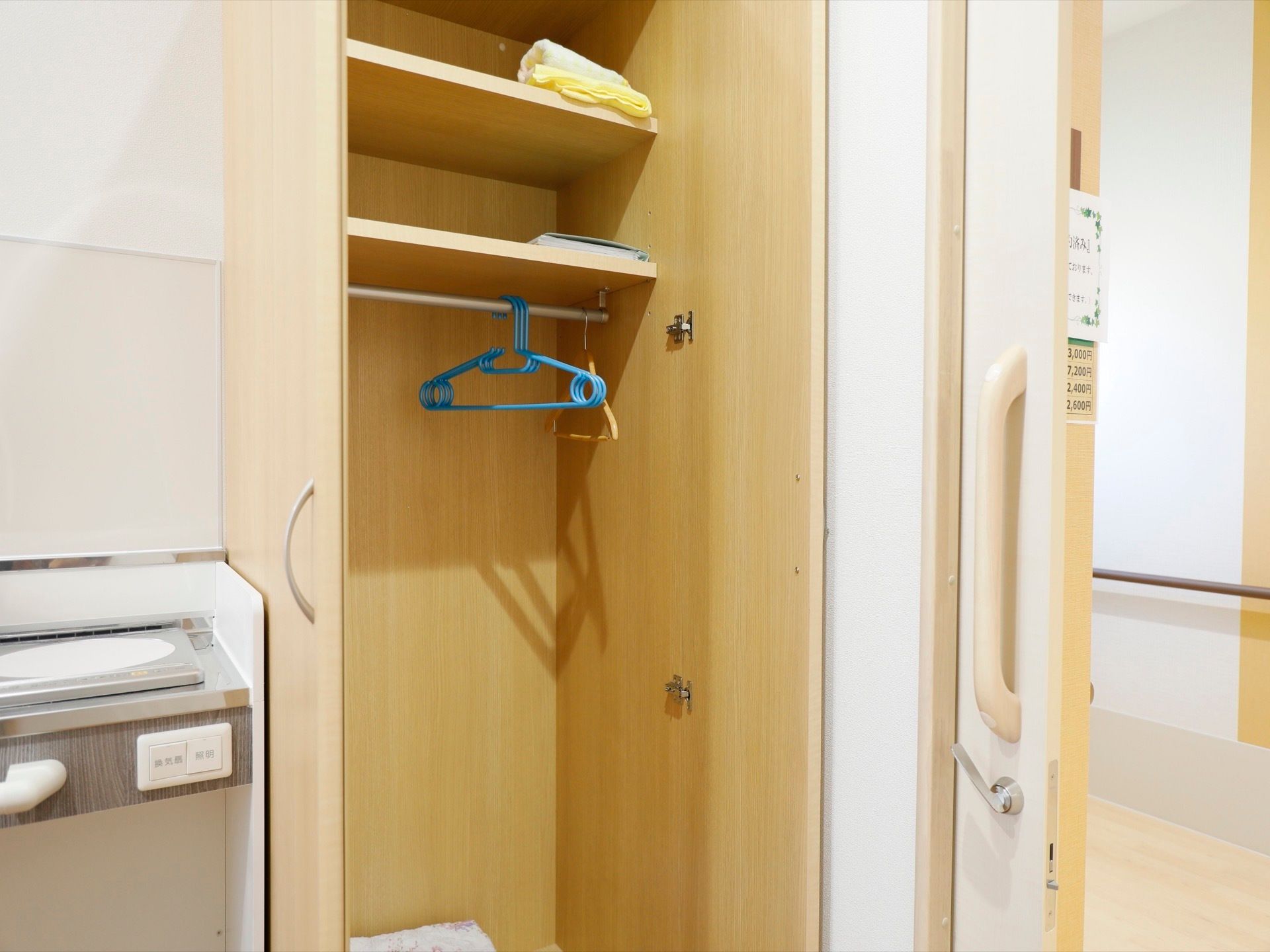 入り口の脇に両開きのクローゼットが設置されている。上部に２段の棚がついており、小物の収納がしやすくなっている。
