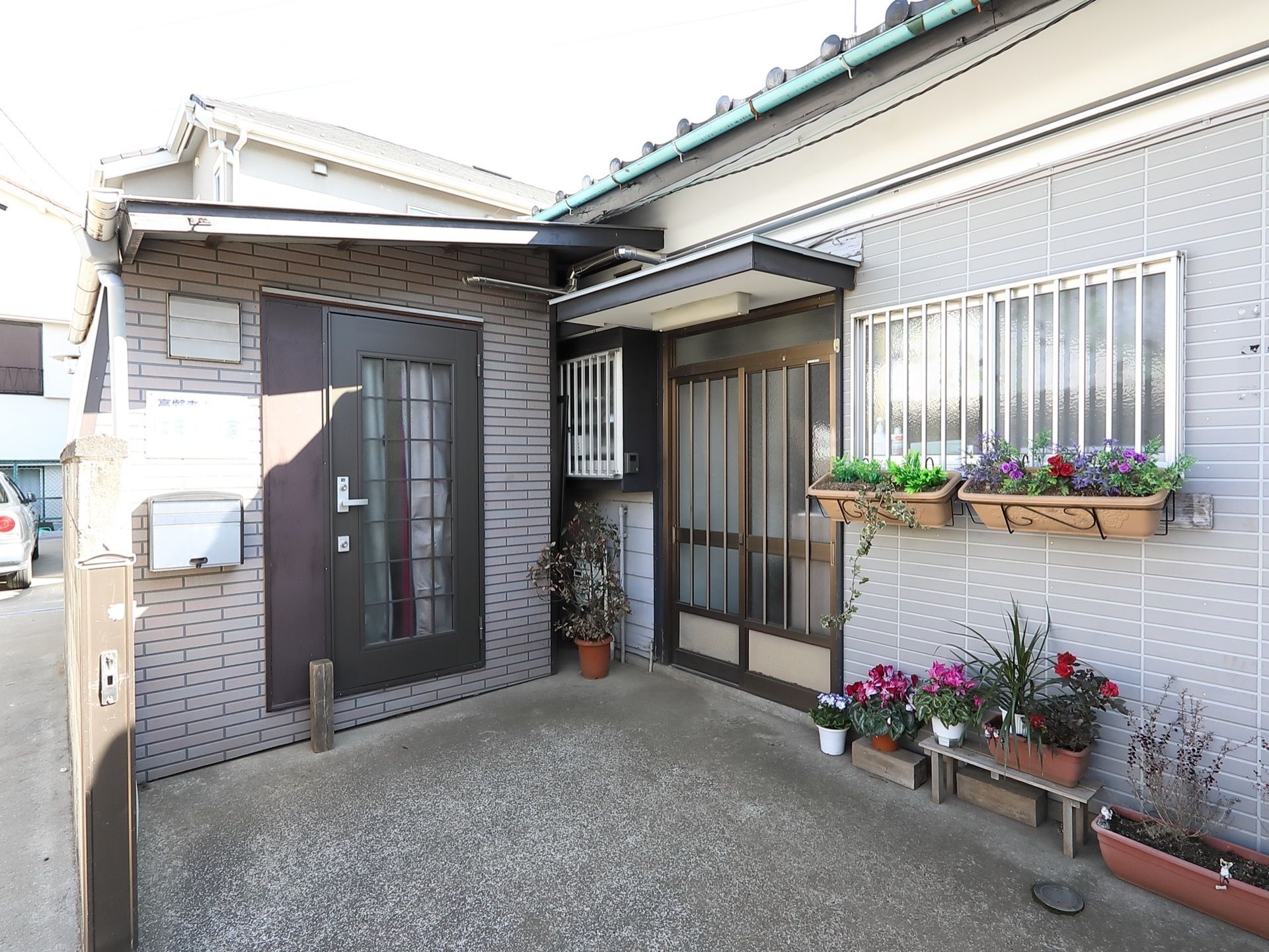 花の咲く鉢植えが飾られた高齢者施設の玄関前