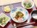 うな丼に野菜の小鉢、フルーツに汁物といった内容の食事。