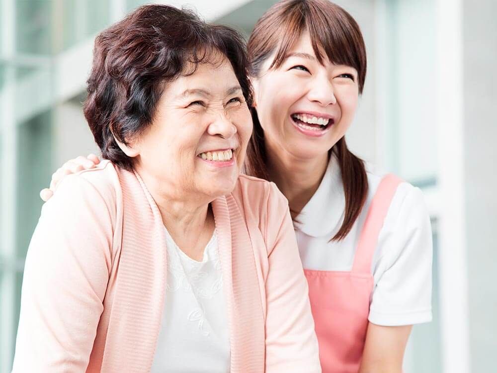 笑顔の高齢女性と付き添いの女性ヘルパー
