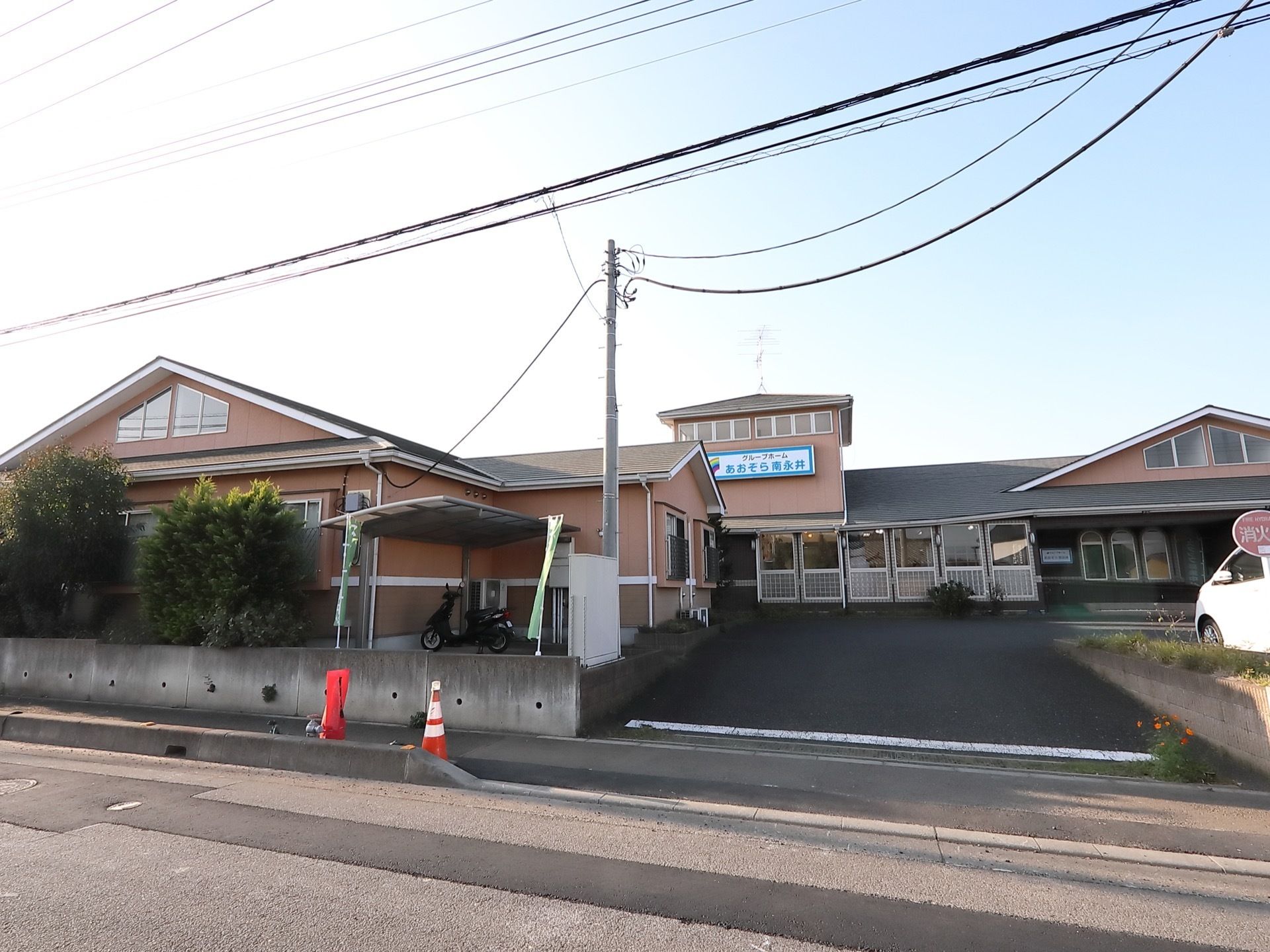 道路に面した場所にある、平屋建ての大きな建物がある。敷地への入り口は緩やかな坂になっている。建物の脇には駐輪スペースがある。
