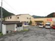 建物が2つ並んで建てられており、建物の奥には森などの自然が広がっている。施設前には小屋があり、自転車が置かれている。