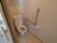 居室内には洋式トイレが用意されている。壁には固定式の手すりが設置され、非常ボタンが取りつけられている。