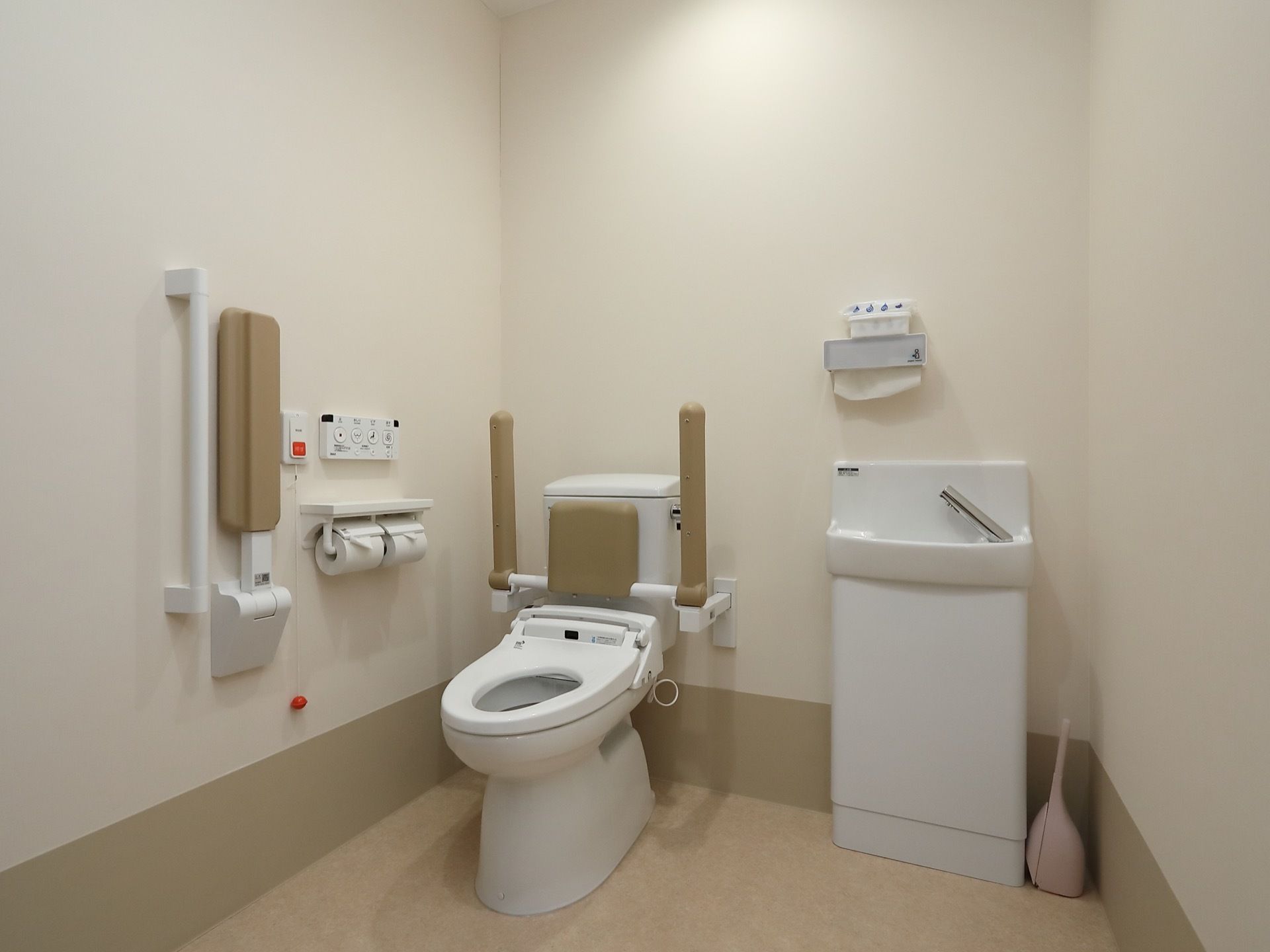 洗面台も備わった車椅子対応トイレである。温水洗浄便座や可動式手すり、呼び出しボタンが完備されている。