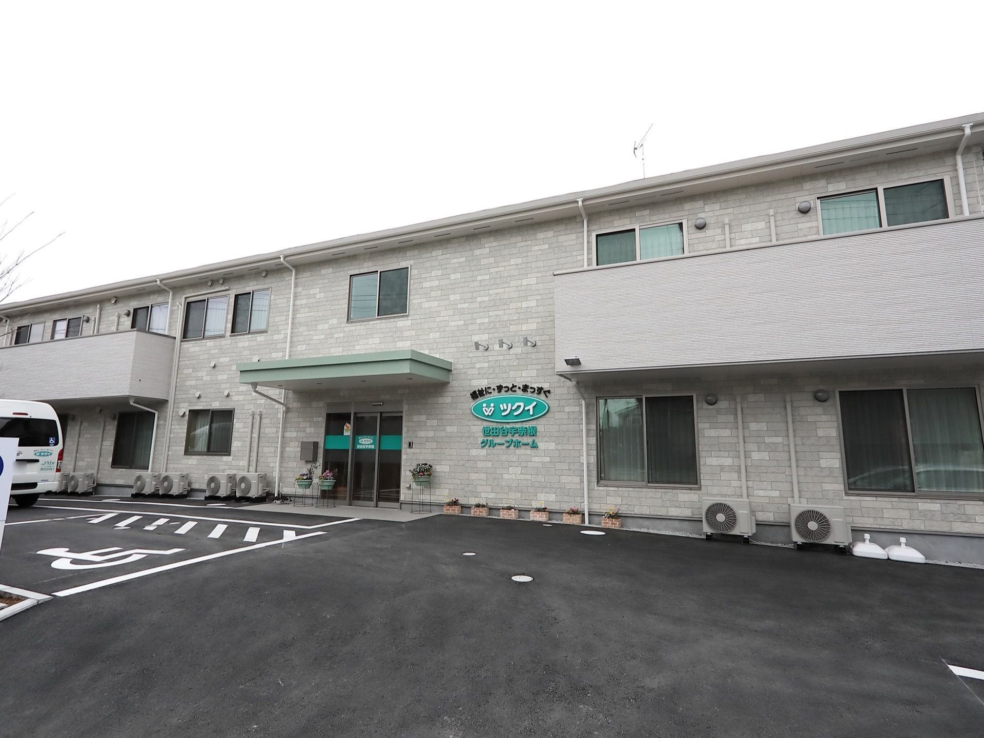 施設は２階建ての建物である。２階の居室には、バルコニーが設置されている。広い駐車場が建物の前に設けられている。