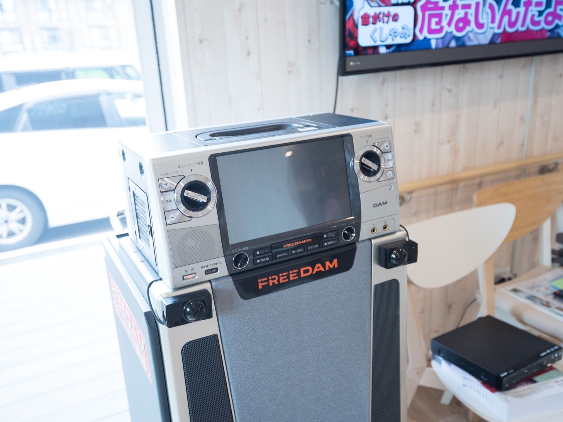 壁にテレビが掛けられたフロアがあり、窓際にはカラオケ用の機材が設置されている。窓からは駐車場が見える。