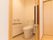 温水洗浄便座を採用したトイレを設置している。壁に手すりがあり、立ち座りの際に体を支えることができる。