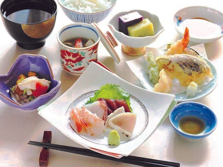 机の上に天ぷらとお刺身、ご飯、汁物、羊羹が乗っている。
